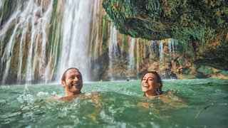 Mann und Frau baden am Wasserfall